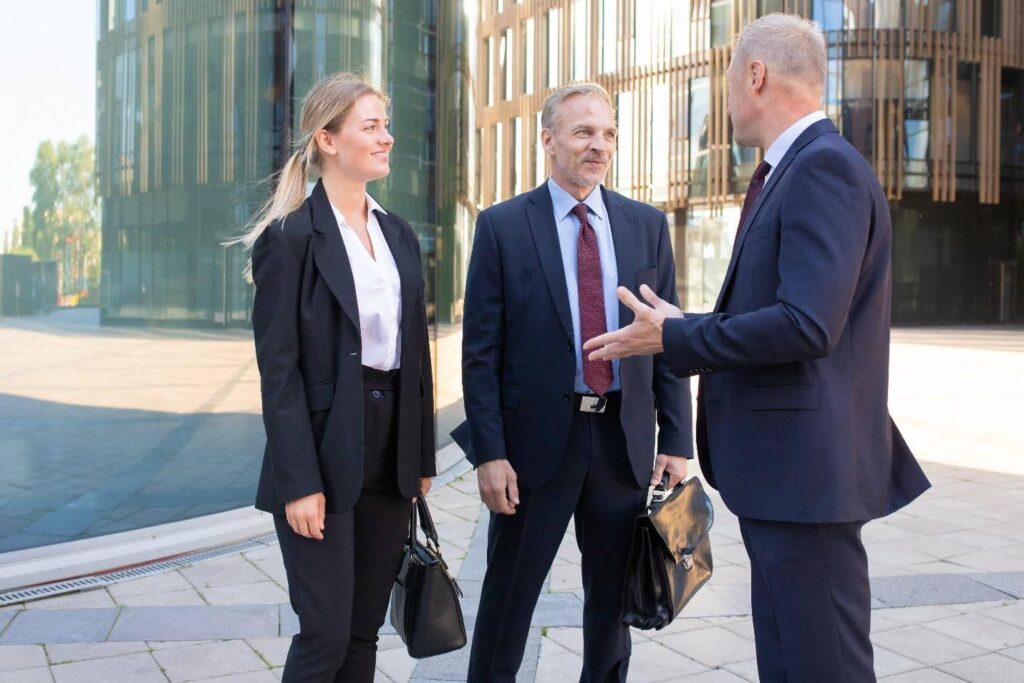 Three registered process servers in suits talking